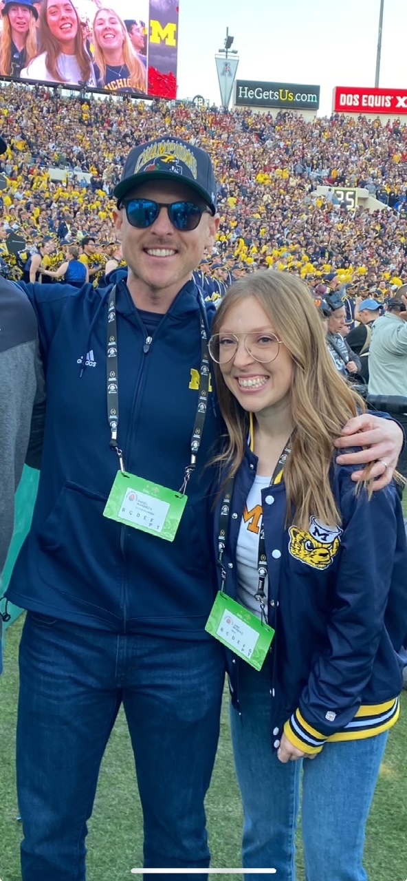 Two people in U-M gear on the field of the Rose Bowl in 2024.